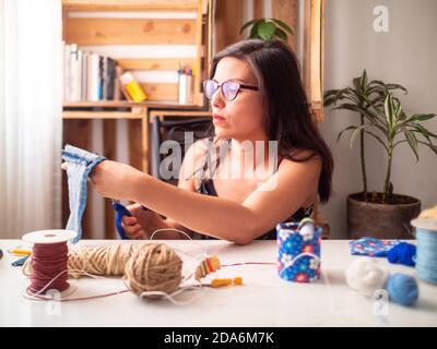 Eine junge Frau schneidet Tuch Stockfoto