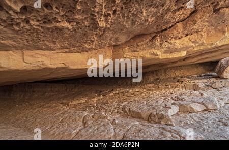 Ein Blick auf den Eingang der Nekarot-Höhle im makhtesh ramon Krater in israel zeigt die verschiedenen Farben von Kalkstein Und Dolomitgesteine und Steine Stockfoto