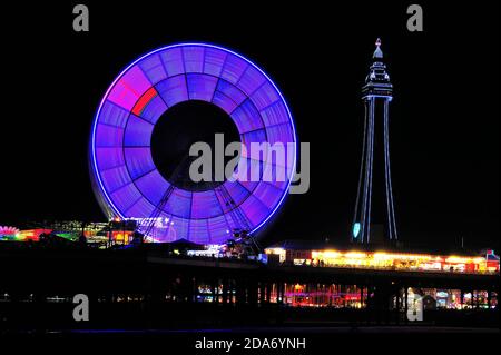 Die vielen Farben des Blackpool Tower und das Riesenrad Nachts während der jährlichen Beleuchtung Stockfoto