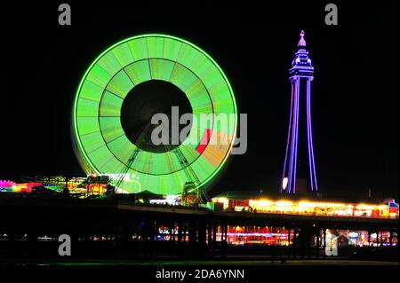 Die vielen Farben des Blackpool Tower und das Riesenrad Nachts während der jährlichen Beleuchtung Stockfoto