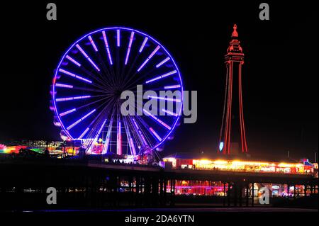 Die vielen Farben des Blackpool Tower und das Riesenrad Nachts während der jährlichen Beleuchtung Stockfoto