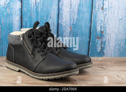 Stiefel mit Lederisolierung auf einem Holzhintergrund Stockfoto