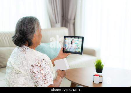 Asiatische Senior Frau mit Videokonferenz, machen Online-Beratung mit Apotheke Beratung über Krankheit und Medikamente per Videoanruf. Telehehealth, Stockfoto