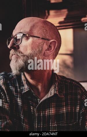 Sitzendes Porträt des Fotografen ein Mann mittleren Alters trägt Brille mit Bart Stockfoto