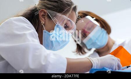 Junge Frau Zahnarzt. Empfang beim Kieferorthopäden. Austausch der Zahnspangen. Polieren. Gelverklebung. Stockfoto