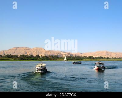 Ägyptische Boote mit Touristen auf dem Nil in der Nähe von Luxor, Ägypten, Afrika. Stockfoto