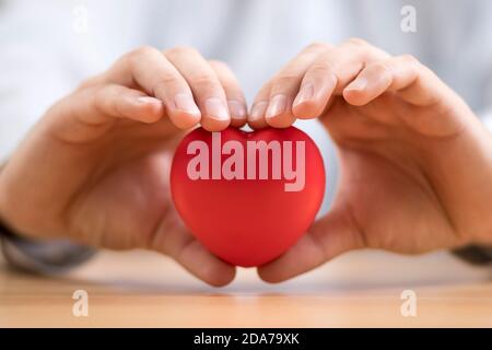 Rotes Herz in den Händen. Krankenversicherung oder Liebeskonzept. Stockfoto