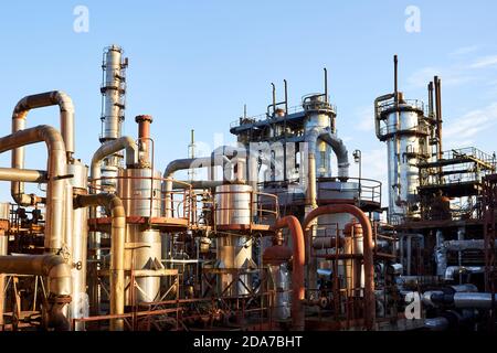 Alte Destillationskolonnen und Reaktoren unter blauem Abendhimmel Hintergrund bei Chemieanlage. Außen aus Silber Metall rostigen Unternehmen, mit Kopys Stockfoto