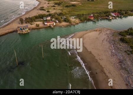 Schöne Landschaften der Täler in der Nähe von Ravenna, Fiumi Uniti, wo der Fluss ins Meer fließt mit den typischen Fischerhütten bei Sonnenuntergang Stockfoto