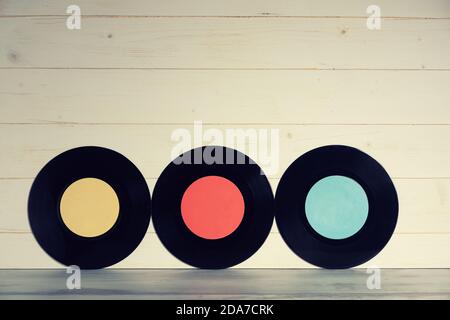 Drei Vinyl-Schallplatten auf Holzhintergrund, alte Vinylplatten isoliert Stockfoto