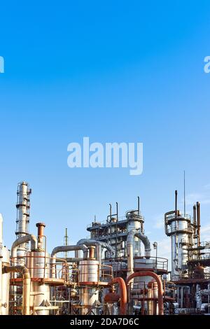 Alte Destillationskolonnen und Reaktoren unter blauem Abendhimmel Hintergrund bei Chemieanlage. Außen aus Silber Metall rostigen Unternehmen, vertikal w Stockfoto