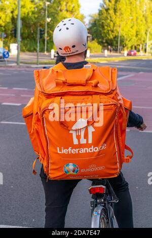 Berlin. Oktober 2020. 12. Oktober 2020, Berlin, ein Fahrradkurier des Fast-Food-Lieferdienstes Lieferando mit Helm in Berlin. Mit einem recht großen, orangefarbenen Rucksack wird das bestellte Essen per Fahrrad geliefert. Das Logo der UEFA EURO2020, Fußball-Europameisterschaft mit dem Zusatz: "Stolzer Partner" ist auch auf den Transporttaschen. --- nur für redaktionelle Zwecke! --- nur für redaktionelle Verwendung! Quelle: dpa/Alamy Live News Stockfoto