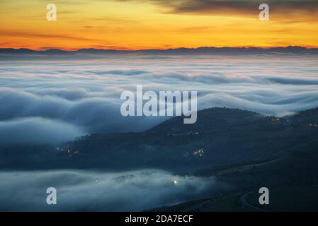 Blaue Nebelwellen vor Sonnenaufgang zwischen Bergen und Tälern Entlang des Camino de Santiago in Triacastela Galicia Stockfoto