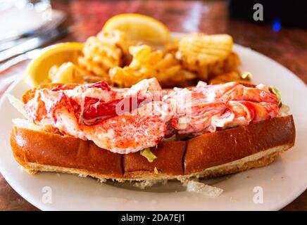 Ein frischer Hummer Brötchen serviert mit Waffel Pommes in einem Restaurant in Portland Maine. Stockfoto