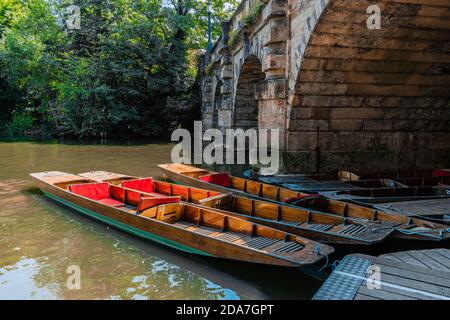 Boote von Magdalen Bridge Boathouse auf dem Cherwell in Oxford dockten viele Boote in Reihen aneinander. Helle und bunte Gruppe von langen Booten Stockfoto