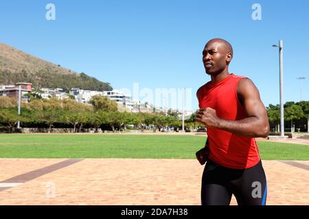 Porträt eines jungen afrikanischen Sportlers, der draußen im Park läuft Stockfoto