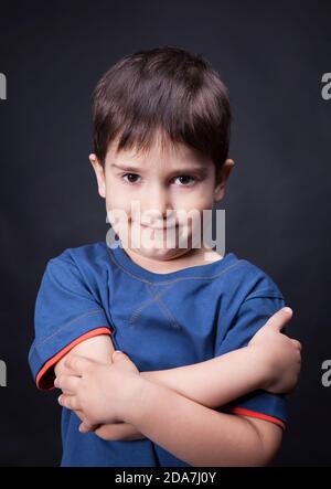 Porträt eines Jungen mit einem skeptischen Blick auf seine Gesicht und gekreuzte Arme Stockfoto