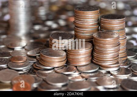 Fokussiere Silbermünzen, goldene Münzen aufeinander gestapelt in verschiedenen Positionen. Ein Stapel Münzen auf Baht-Münze Hintergrund. Stockfoto