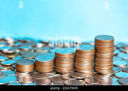 Nahaufnahme Silbermünzen, Goldmünzen übereinander gestapelt in verschiedenen Positionen. Ein Stapel Münzen auf Baht-Münze Hintergrund. Sparkonzept. Stockfoto