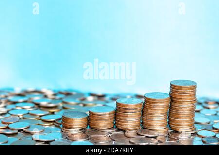 Nahaufnahme Silbermünzen, Goldmünzen übereinander gestapelt in verschiedenen Positionen. Ein Stapel Münzen auf Baht-Münze Hintergrund. Sparkonzept. Stockfoto