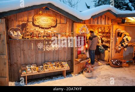 Ettal, Deutschland/Bayern – 31. Dezember 2019: Verschneite Weihnachtsmärkte mit beleuchteten Geschäften in Holzhütten mit Geschenken und handgefertigter Dekoration. Stockfoto