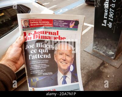 Paris, Frankreich - 9. Nov 2020: POV-Mann kauft französische Zeitungskiosk am Pressekiosk mit Joe Bidens prognostizierten US-Präsidentschaftswahlsieg gegen den Amtsinhaber Donald Trump Stockfoto