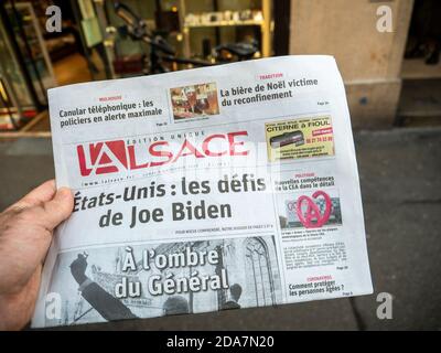 Paris, Frankreich - 9. Nov 2020: POV männliche Hand kaufen in der Presse Kiosk Zeitung l'Alsace mit Herausforderungen von Joe Bidens geplanter US-Präsidentschaftswahl-Sieg gegen den Amtsinhaber Donald Trump Stockfoto