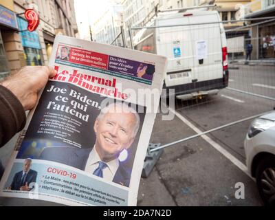 Paris, Frankreich - 9. Nov 2020: POV-Mann kauft französische Zeitungskiosk am Pressekiosk mit Joe Bidens prognostizierten US-Präsidentschaftswahlsieg gegen den Amtsinhaber Donald Trump Stockfoto