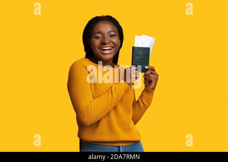 Happy African Weiblich Traveller Posiert Mit Pass Und Tickets Auf Gelbem Hintergrund, Stockfoto