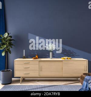 Interieur-Szene in blauer Farbstimmung: Holz-Sideboard mit Blumen, Schalen und eine Kerze auf der Oberseite. Feigenbaum, Korbkorb und Teppich auf Hartholzboden - CO Stockfoto