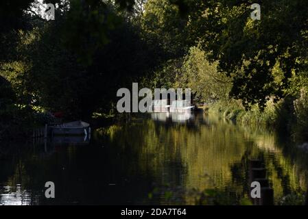 Zwei Narrow Boats spiegeln sich in den stillen Gewässern des Schönen Basingstoke Canal in der Nähe der Gerstenmähbrücke in Dogmersfield Stockfoto