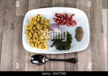 Zutaten für Cappelletti Pancetta und Spargel in einer Pfanne Mit Parmesan Stockfoto