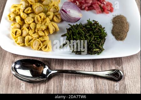 Zutaten für Cappelletti Pancetta und Spargel in einer Pfanne Mit Parmesan Stockfoto