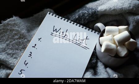 Weihnachtshintergrund mit leerer Wunschliste, Kaffeebecher mit Marshmallow Stockfoto