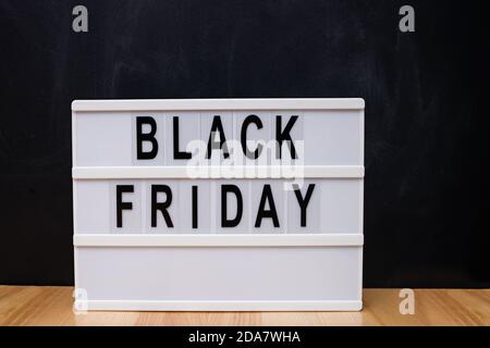 Text Black Friday auf Leuchtkasten bei schwarzer Wand Stockfoto