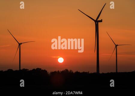 Haltern, NRW, 10. November 2020. Die Sonne scheint hinter drei Windturbinen untergegangen zu sein. Ein schöner Sonnenuntergang schließt einen milden, sonnigen Tag im Münsterland ab. Kredit: Imageplotter/Alamy Live Nachrichten Stockfoto