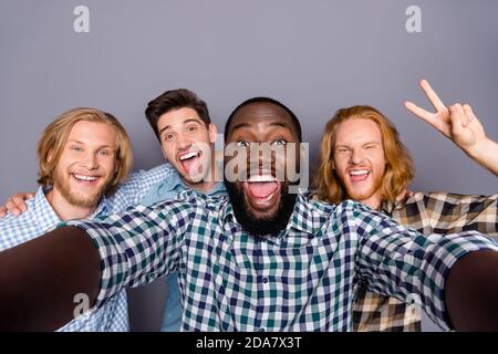 Selbstportrait von vier schönen attraktiven funky fröhlich positive Jungs Umarmt Spaß haben Treffen Klassenkameraden zeigen V-Zeichen Narren isoliert Stockfoto