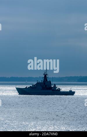 Ein britisches Kriegsschiff der königlichen Marine vor Anker bei Sonnenuntergang im solent vor der Küste der Insel wight, großbritannien Stockfoto