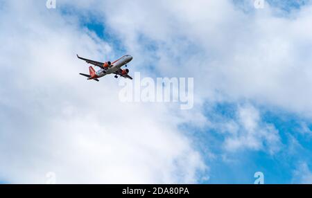 EasyJet-Flugzeug, das oben in Wolken und blauem Himmel fliegt, Schottland, Großbritannien Stockfoto