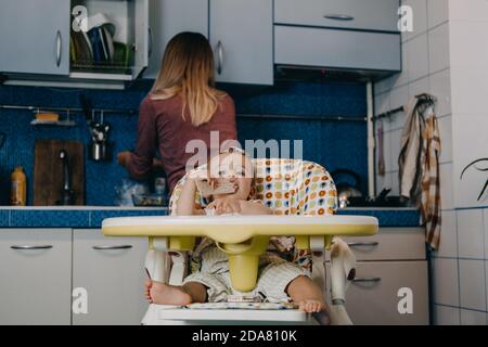 Babynahrung. Beste Finger Lebensmittel für Kleinkinder Babys. Kleinkind Baby Mädchen mit Knäckebrot, Müsli Cracker sitzen in Fütterungssessel. Stockfoto