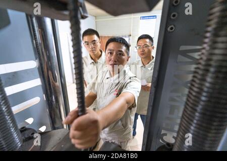 (201110) -- VIENTIANE, 10. November 2020 (Xinhua) -- Xu Zhou (vorne) überprüft die Ausrüstung im Büro des China-Laos Eisenbahnprojekts am nördlichen Stadtrand von Vientiane, Hauptstadt von Laos, 5. August 2020. Die China-Laos-Eisenbahn ist ein strategisches Andockprojekt zwischen der von China vorgeschlagenen Belt and Road Initiative und der laotischen Strategie, das Binnenland in einen an Land gebundenen Knotenpunkt zu verwandeln. Der chinesische Ingenieur Xu Zhou, der mit der Medaille vom 4. Mai ausgezeichnet wurde, eine nationale Spitzenauszeichnung für junge Chinesen, führt seine Gruppe von der China Railway No. 2 Engineering Group (CREC-2) an, um die Aufgabe in der Sub zu erfüllen Stockfoto