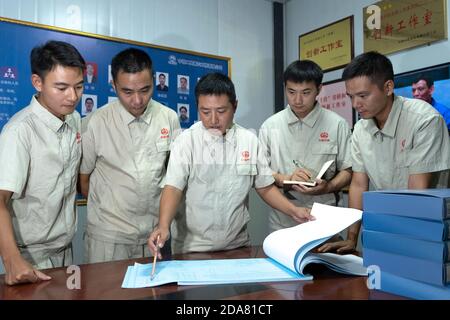 (201110) -- VIENTIANE, 10. November 2020 (Xinhua) -- Xu Zhou (C) macht einen Punkt, als er mit seinen Kollegen über technische Probleme im Büro des China-Laos-Eisenbahnprojekts am nördlichen Stadtrand von Vientiane, Hauptstadt von Laos, spricht, 5. August 2020. Die China-Laos-Eisenbahn ist ein strategisches Andockprojekt zwischen der von China vorgeschlagenen Belt and Road Initiative und der laotischen Strategie, das Binnenland in einen an Land gebundenen Knotenpunkt zu verwandeln. Der chinesische Ingenieur Xu Zhou, der mit der Medaille vom 4. Mai ausgezeichnet wurde, eine nationale Spitzenauszeichnung für junge Chinesen, führt seine Gruppe vom chinesischen Eisenbahningenieur Nr. 2 an Stockfoto