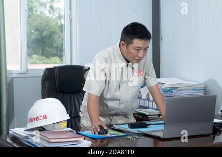 (201110) -- VIENTIANE, 10. November 2020 (Xinhua) -- Xu Zhou prüft Dokumente im Büro des China-Laos Eisenbahnprojekts am nördlichen Stadtrand von Vientiane, Hauptstadt von Laos, 5. August 2020. Die China-Laos-Eisenbahn ist ein strategisches Andockprojekt zwischen der von China vorgeschlagenen Belt and Road Initiative und der laotischen Strategie, das Binnenland in einen an Land gebundenen Knotenpunkt zu verwandeln. Der chinesische Ingenieur Xu Zhou, der mit der Medaille vom 4. Mai ausgezeichnet wurde, eine nationale Spitzenauszeichnung für junge Chinesen, führt seine Gruppe von der China Railway No. 2 Engineering Group (CREC-2) an, um die Aufgabe in den Vororten von durchzuführen Stockfoto