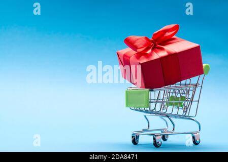 Korb mit einem großen roten Geschenk auf blauem Hintergrund Mit Ort für Text Stockfoto