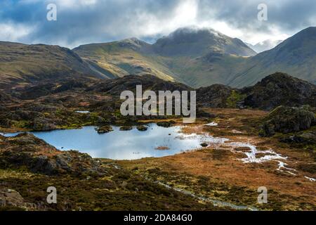 Innaminate Tarn on Haystacks in the Buttermere Fells, Lake District National Park, Cumbria, Großbritannien. Großer Gabel und grüner Gabel in der Ferne. Stockfoto