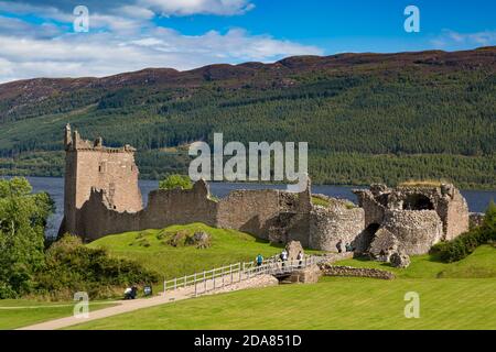 Touristen besuchen Ruinen von Urquhart Castle entlang der Ufer des Loch Ness, Highlands, Schottland Stockfoto