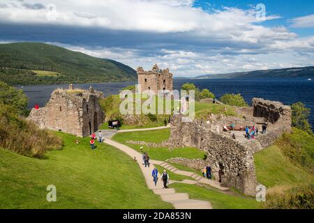 Touristen besuchen Ruinen von Urquhart Castle entlang der Ufer des Loch Ness, Highlands, Schottland Stockfoto