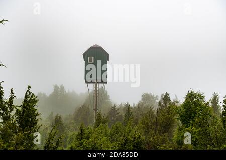 Jagdhütte und Beobachtungsposten, Berg Tara, Straße nach Fort Solotnik, schöner Wald, hohe Vegetation und Morgennebel Stockfoto