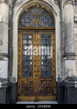 Buenos Aires, Argentinien - 15. Februar 2019: Die rostige Tür des alten Grabes auf dem Friedhof von Recoleta. Holztüren mit geschnitzter Dekoration und Glas Stockfoto