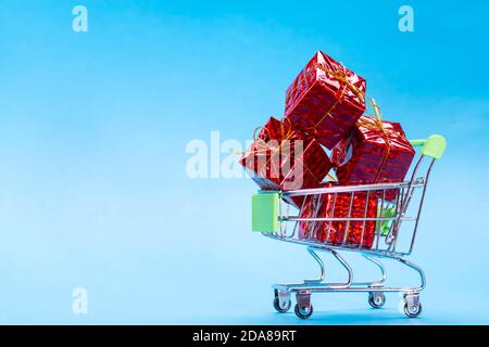 Korb mit Geschenken in rot auf blauem Hintergrund mit Für Text platzieren Stockfoto